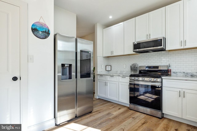 528 N Third St, Martinsburg, WV 25404 - kitchen featuring appliances with stainless steel finishes, decorative backsplash, light wood-style floors, white cabinetry, and recessed lighting