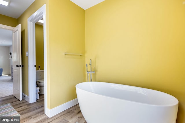 528 N Third St, Martinsburg, WV 25404 - bathroom with a soaking tub, toilet, wood finished floors, and baseboards