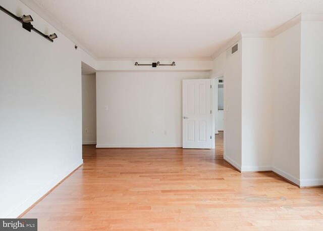 777 7th St NW Unit 913, Washington, DC 20001 - spare room featuring light wood-style flooring, baseboards, and crown molding