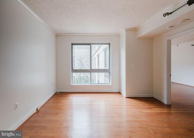 777 7th St NW Unit 913, Washington, DC 20001 - empty room with ornamental molding, a textured ceiling, light wood-style flooring, and baseboards
