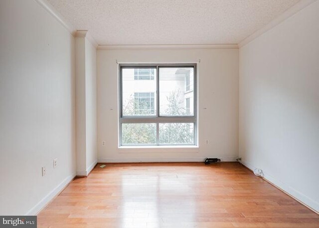 777 7th St NW Unit 913, Washington, DC 20001 - spare room with a textured ceiling, crown molding, light wood finished floors, and baseboards