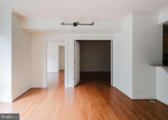 777 7th St NW Unit 913, Washington, DC 20001 - hallway featuring ornamental molding, light wood finished floors, a textured ceiling, and baseboards