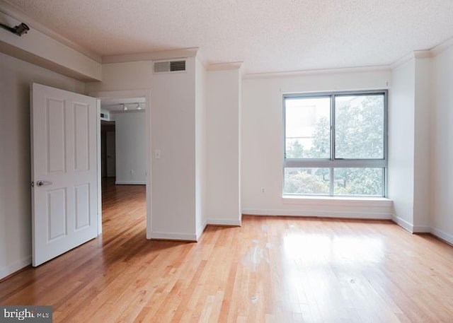 777 7th St NW Unit 913, Washington, DC 20001 - spare room with plenty of natural light, ornamental molding, a textured ceiling, light wood-type flooring, and baseboards
