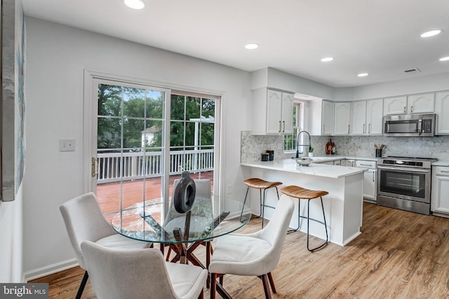 9509 Lincoln Ave, Manassas, VA 20110 - kitchen with appliances with stainless steel finishes, a peninsula, a sink, tasteful backsplash, and recessed lighting
