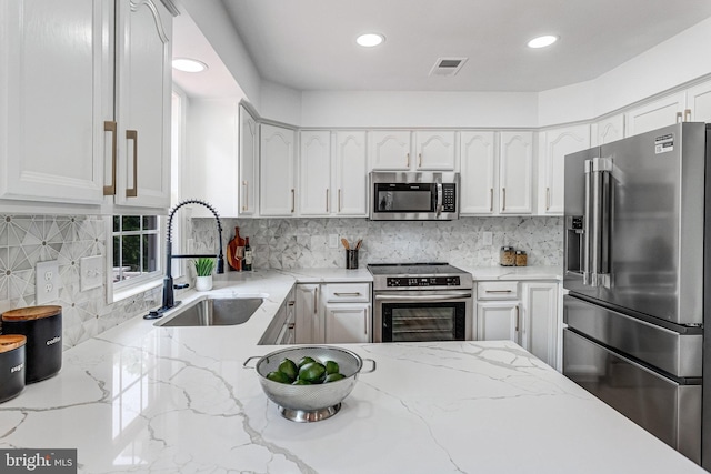 9509 Lincoln Ave, Manassas, VA 20110 - kitchen with stainless steel appliances, a sink, white cabinetry, decorative backsplash, and recessed lighting