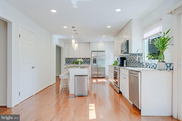 1434 Cellar Creek Way, Herndon, VA 20170 - kitchen featuring stainless steel appliances, tasteful backsplash, a kitchen breakfast bar, white cabinets, and recessed lighting