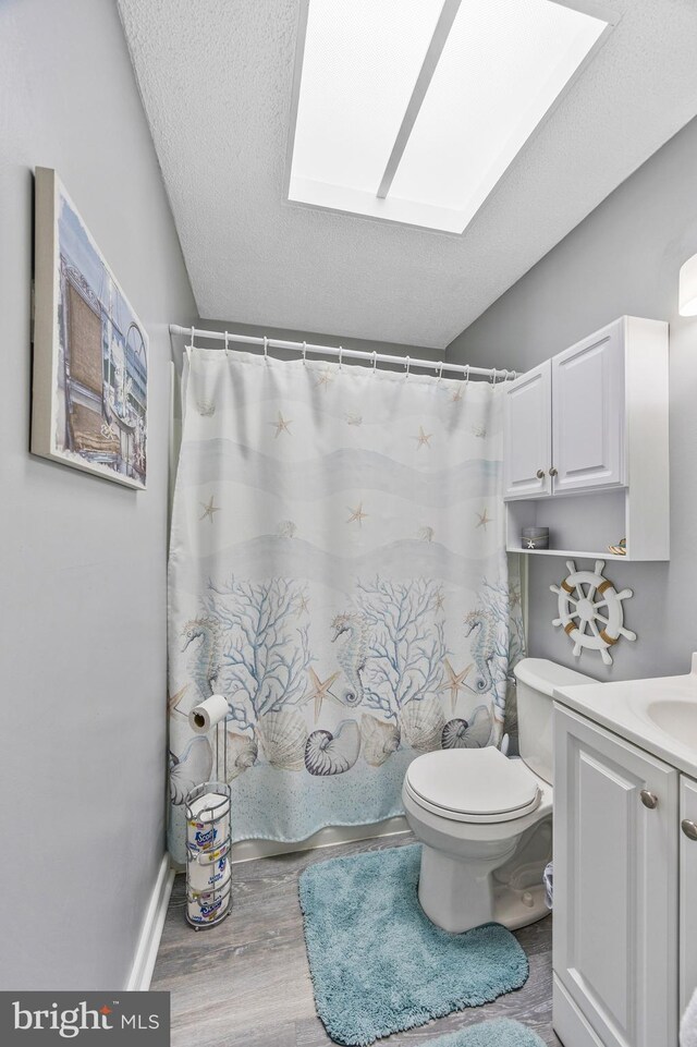 1518 Becklow Ave, Baltimore, MD 21220 - full bathroom featuring vanity, a skylight, toilet, wood finished floors, and a textured ceiling