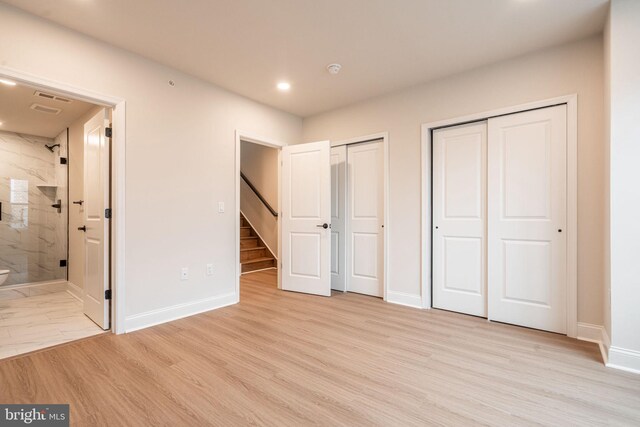 4096 Conshohocken Ave Unit A2, Philadelphia, PA 19131 - unfurnished bedroom featuring multiple closets, recessed lighting, baseboards, ensuite bathroom, and light wood-style flooring