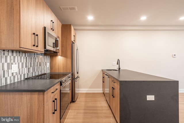 4096 Conshohocken Ave Unit A2, Philadelphia, PA 19131 - kitchen featuring stainless steel appliances, light wood-style flooring, dark countertops, backsplash, and baseboards