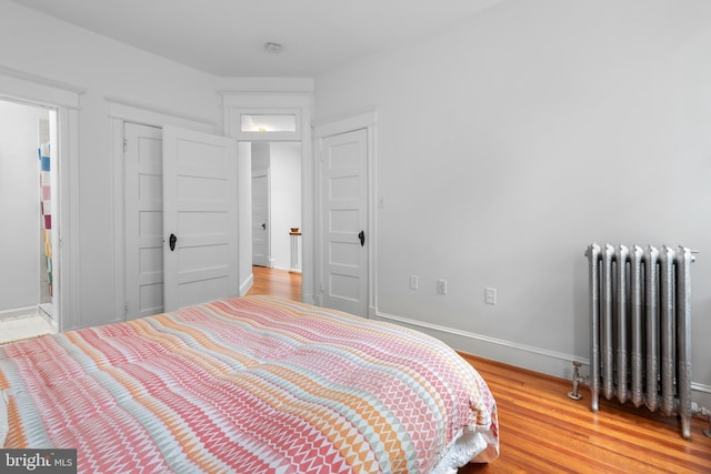 4022 Illinois Ave NW, Washington, DC 20011 - bedroom featuring radiator heating unit, light wood-type flooring, baseboards, and a closet
