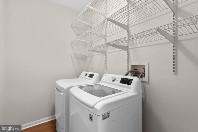 6404 Distant Melody Pl, Columbia, MD 21044 - washroom featuring washing machine and clothes dryer, baseboards, and wood finished floors