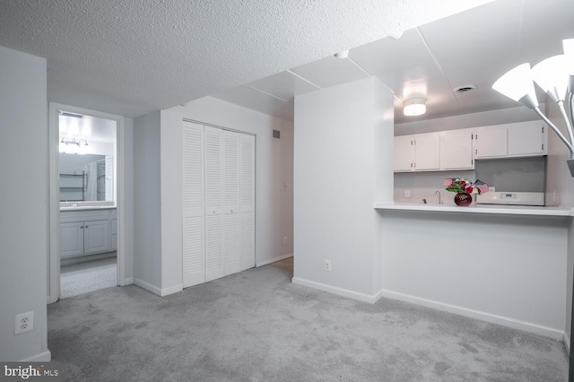 2525 Huntington Ave Unit 18, Alexandria, VA 22303 - kitchen featuring light carpet, white cabinetry, light countertops, a textured ceiling, and baseboards
