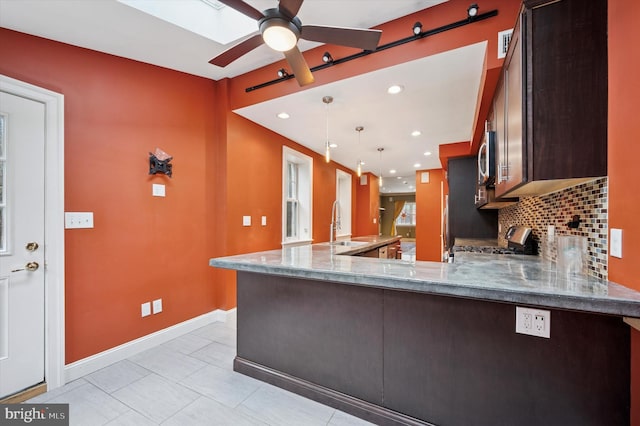 2351 E York St, Philadelphia, PA 19125 - kitchen with gas range, baseboards, dark brown cabinets, a sink, and light stone countertops