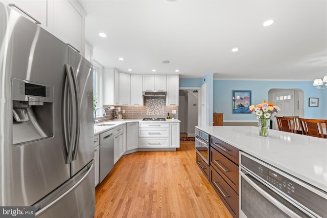 1110 Clover Hill Rd, Wynnewood, PA 19096 - kitchen featuring stainless steel appliances, a sink, white cabinets, light countertops, and recessed lighting