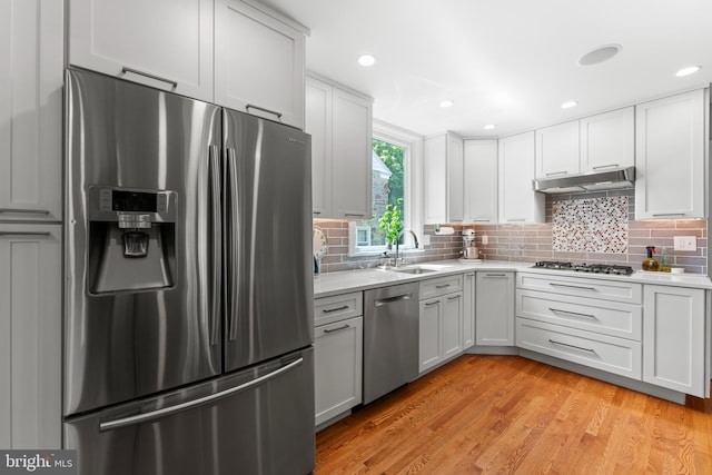 1110 Clover Hill Rd, Wynnewood, PA 19096 - kitchen featuring stainless steel appliances, under cabinet range hood, light countertops, decorative backsplash, and recessed lighting