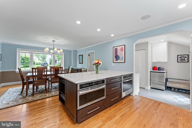 1110 Clover Hill Rd, Wynnewood, PA 19096 - kitchen featuring oven, light countertops, light wood-type flooring, crown molding, and recessed lighting