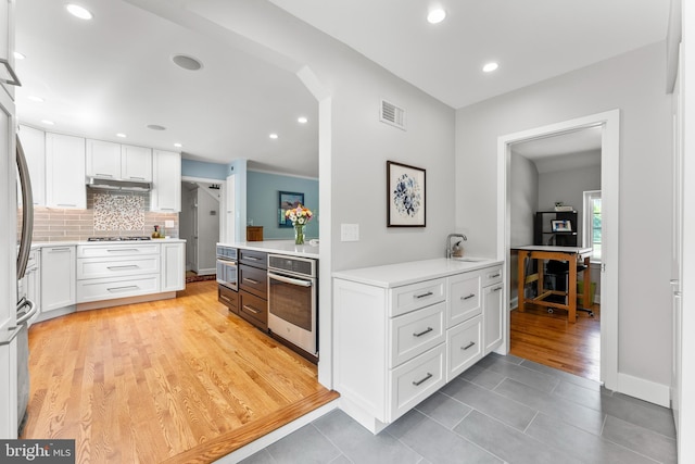 1110 Clover Hill Rd, Wynnewood, PA 19096 - kitchen featuring appliances with stainless steel finishes, white cabinets, a sink, tasteful backsplash, and recessed lighting