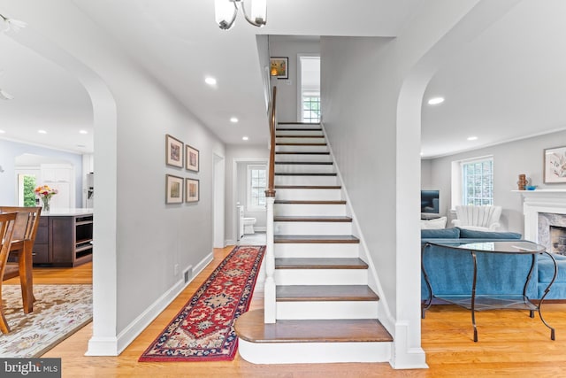 1110 Clover Hill Rd, Wynnewood, PA 19096 - stairs featuring arched walkways, wood finished floors, recessed lighting, a premium fireplace, and baseboards