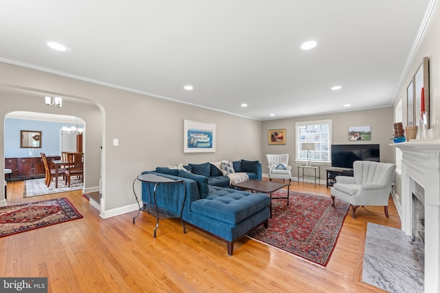 1110 Clover Hill Rd, Wynnewood, PA 19096 - living area with arched walkways, crown molding, light wood-style flooring, baseboards, and a fireplace with flush hearth