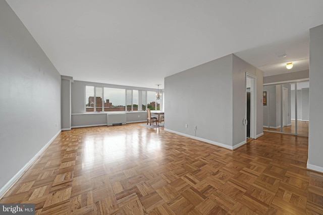 4301 Massachusetts Ave NW Unit 8009, Washington, DC 20016 - unfurnished living room featuring baseboards and a chandelier