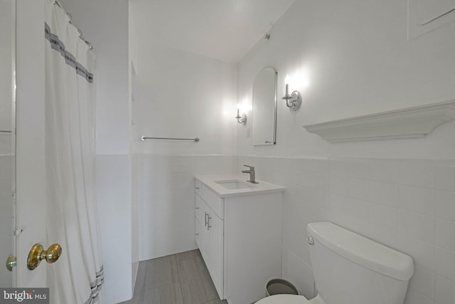 4301 Massachusetts Ave NW Unit 8009, Washington, DC 20016 - full bath with tile walls, vanity, toilet, a wainscoted wall, and a shower with curtain