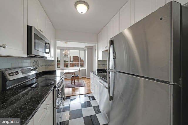 4301 Massachusetts Ave NW Unit 8009, Washington, DC 20016 - kitchen with stainless steel appliances, a chandelier, white cabinets, backsplash, and dark stone countertops