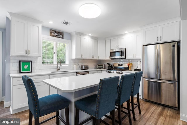 420 Conifer Dr, Forked River, NJ 08731 - kitchen with stainless steel appliances, a sink, a breakfast bar area, decorative backsplash, and recessed lighting