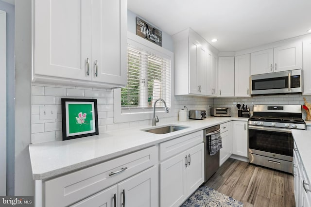420 Conifer Dr, Forked River, NJ 08731 - kitchen featuring appliances with stainless steel finishes, a sink, white cabinetry, decorative backsplash, and recessed lighting