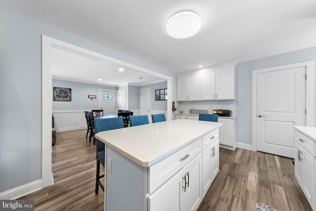 420 Conifer Dr, Forked River, NJ 08731 - kitchen with wood finished floors, a breakfast bar area, white cabinets, light countertops, and a center island