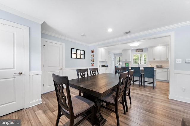 420 Conifer Dr, Forked River, NJ 08731 - dining room with wainscoting, light wood-type flooring, crown molding, and a decorative wall