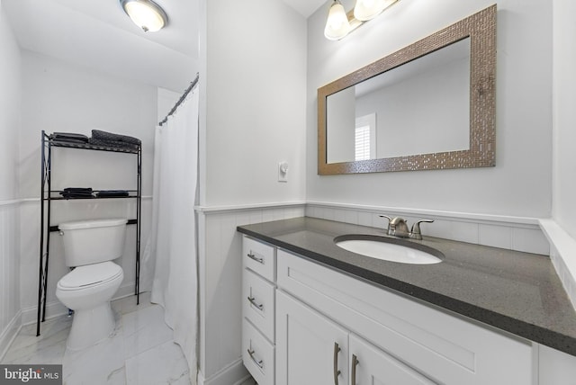 420 Conifer Dr, Forked River, NJ 08731 - bathroom featuring vanity, toilet, marble look tiles, and a wainscoted wall