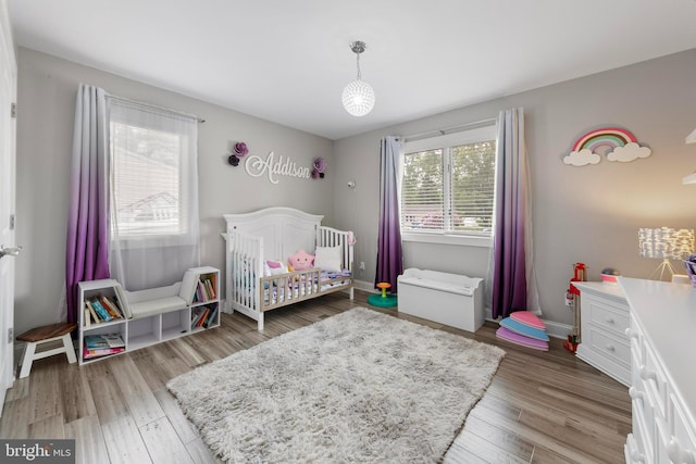 420 Conifer Dr, Forked River, NJ 08731 - bedroom with a crib, wood finished floors, and baseboards