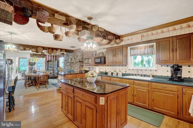 1150 S Mountain Rd, Dillsburg, PA 17019 - kitchen with black microwave, a sink, brown cabinetry, light wood-type flooring, and a kitchen island