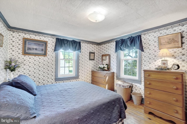 1150 S Mountain Rd, Dillsburg, PA 17019 - bedroom featuring hardwood / wood-style floors, ornamental molding, multiple windows, and wallpapered walls