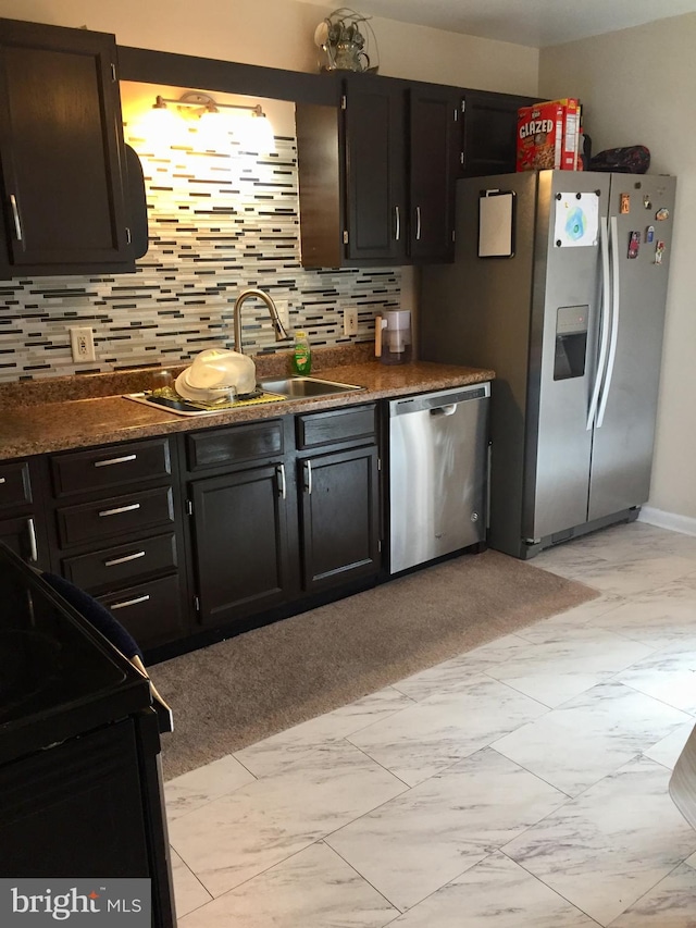 942 Monroe St, Harrisburg, PA 17113 - kitchen featuring appliances with stainless steel finishes, dark countertops, decorative backsplash, and light marble finish flooring
