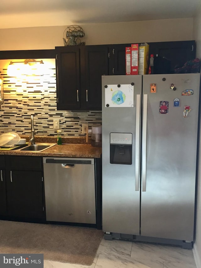 942 Monroe St, Harrisburg, PA 17113 - kitchen featuring stainless steel appliances, a sink, light marble finish floors, dark countertops, and dark cabinets