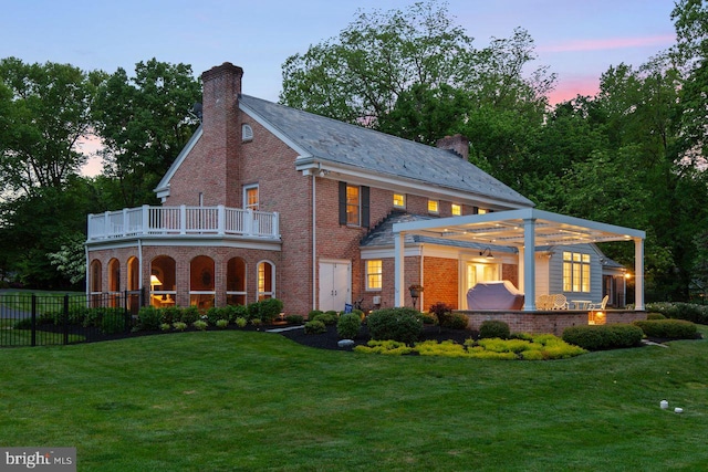 121 Eshelman Rd, Lancaster, PA 17601 - back of property at dusk featuring a chimney, a balcony, brick siding, and a pergola
