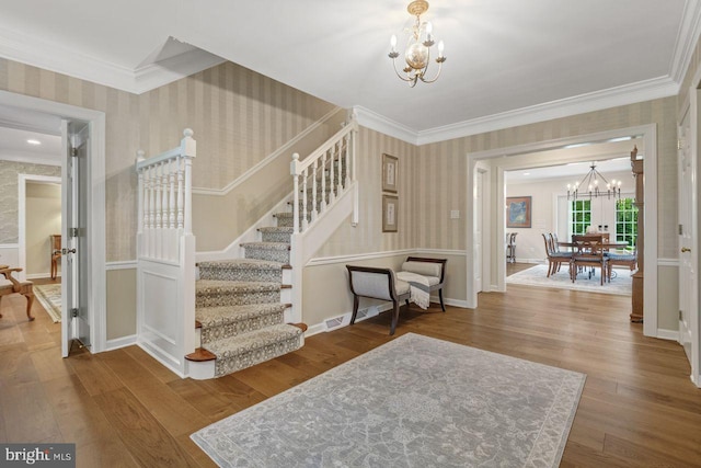 121 Eshelman Rd, Lancaster, PA 17601 - stairway featuring a chandelier, wallpapered walls, ornamental molding, wood finished floors, and baseboards