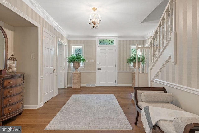 121 Eshelman Rd, Lancaster, PA 17601 - entrance foyer featuring a chandelier, wood finished floors, stairs, wallpapered walls, and crown molding