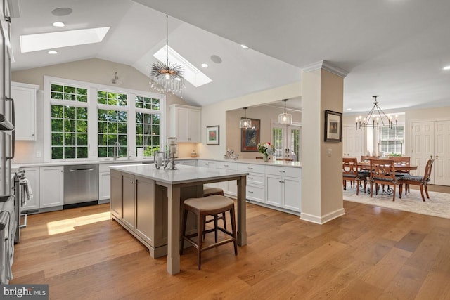 121 Eshelman Rd, Lancaster, PA 17601 - kitchen featuring stainless steel dishwasher, a skylight, a breakfast bar area, light wood-style floors, and light countertops
