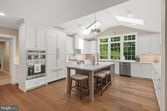 121 Eshelman Rd, Lancaster, PA 17601 - kitchen featuring stainless steel appliances, a skylight, white cabinetry, tasteful backsplash, and lofted ceiling