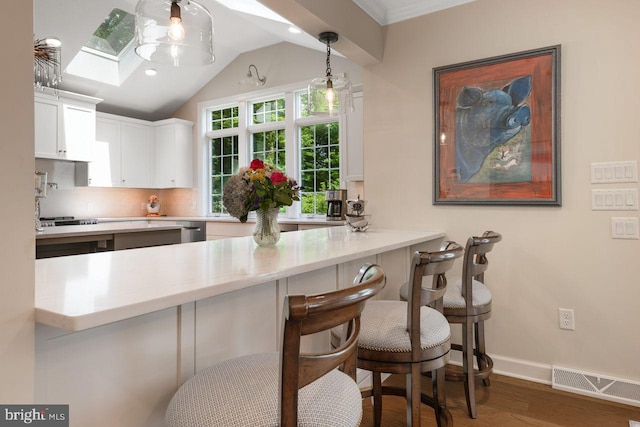 121 Eshelman Rd, Lancaster, PA 17601 - kitchen featuring wood finished floors, backsplash, stainless steel dishwasher, white cabinets, and light countertops