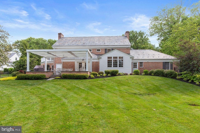 121 Eshelman Rd, Lancaster, PA 17601 - rear view of property featuring a chimney, a lawn, and brick siding