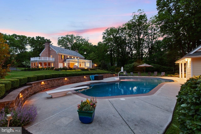 121 Eshelman Rd, Lancaster, PA 17601 - pool at dusk featuring a diving board, a patio area, an outdoor pool, and a yard