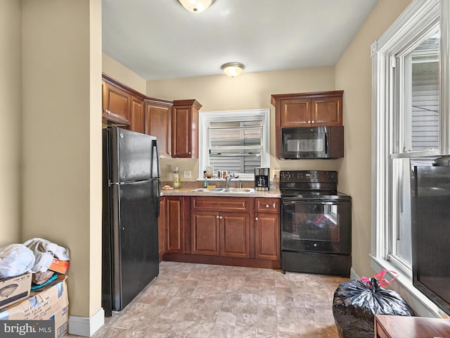 225 S State St, Ephrata, PA 17522 - kitchen with black appliances, a sink, brown cabinetry, and stone finish flooring