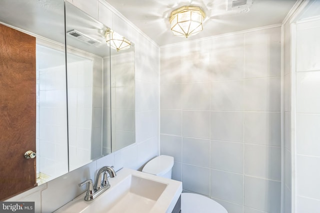 7910 Polk St, Lanham, MD 20706 - half bathroom featuring toilet, tile walls, vanity, and ornamental molding