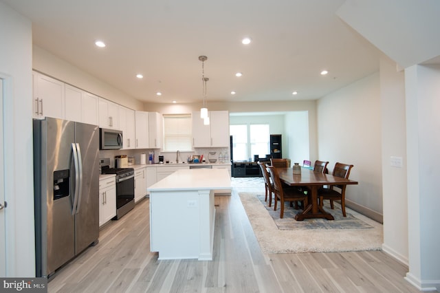 305 Shipyard Dr Unit 61, Cambridge, MD 21613 - kitchen with stainless steel appliances, a sink, a kitchen island, light wood finished floors, and light countertops