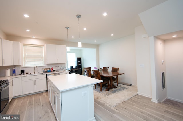 305 Shipyard Dr Unit 61, Cambridge, MD 21613 - kitchen with light wood-type flooring, black gas range, white cabinetry, recessed lighting, and a sink
