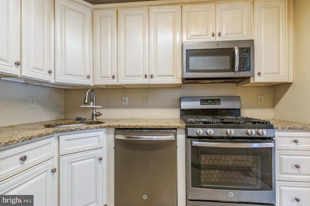136 Chalkboard Ct, Moorestown, NJ 08057 - kitchen with appliances with stainless steel finishes, a sink, white cabinets, and light stone counters