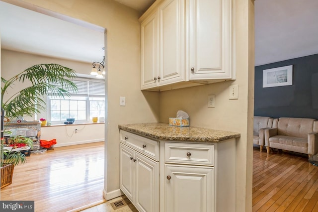 136 Chalkboard Ct, Moorestown, NJ 08057 - kitchen featuring light wood finished floors, baseboards, light stone counters, and white cabinets